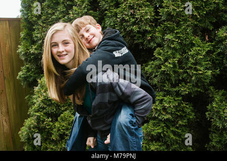 Bruder und Schwester mit ihrer kleinen Schwester im Korb