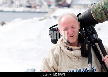 Fotograf mit einem großen Objektiv (600 mm) im Schnee Stockfoto