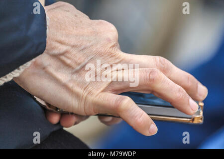 Menschliche Hand berühren ein Mobiltelefon Stockfoto