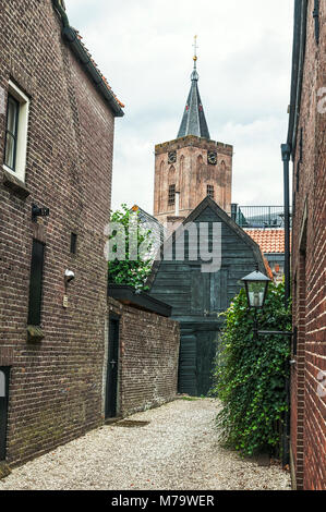 Innen Blick auf alte holländische Häuser mit einem Kirchturm im Hintergrund Stockfoto