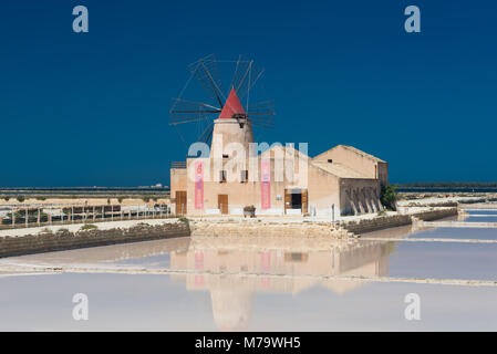 Die Salt Museum mit einer Windmühle mit Reflexion in den Salinen am Salina Mozia an der Westküste von Sizilien zwischen Trapani und Marsala. Stockfoto