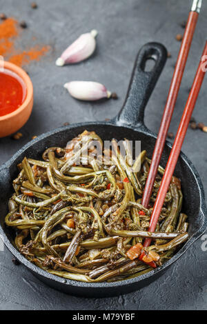 Pikanter Salat von fern mit Zwiebel, Knoblauch, Sojasauce und Gewürzen. Teller Östlichen und asiatischen Küche. Selektiver Fokus Stockfoto