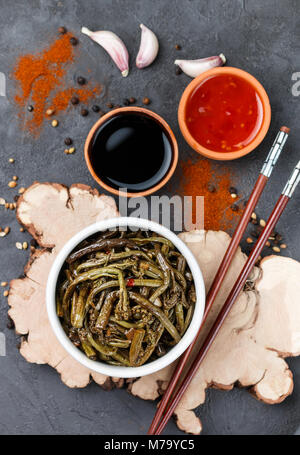 Pikanter Salat von fern mit Zwiebel, Knoblauch, Sojasauce und Gewürzen. Teller Östlichen und asiatischen Küche. Selektiver Fokus Stockfoto