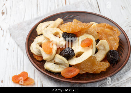 Gesundes Essen. Mix aus getrockneten Früchten in einem irdenen Schüssel - Äpfel, Birnen, Pflaumen, Aprikosen, close-up. Selektiver Fokus Stockfoto