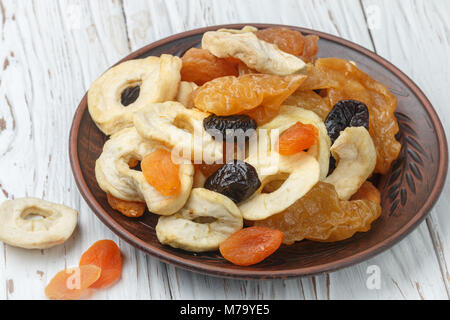 Gesundes Essen. Mix aus getrockneten Früchten in einem irdenen Schüssel - Äpfel, Birnen, Pflaumen, Aprikosen, close-up. Selektiver Fokus Stockfoto