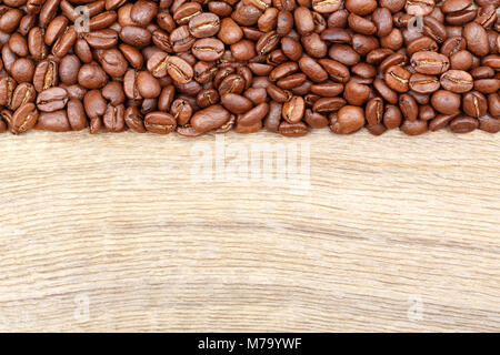Kaffeebohnen auf alten Holztisch. Ansicht von oben. Stockfoto
