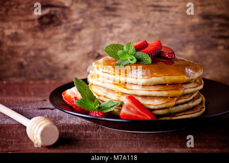 Bündel hausgemachte Pfannkuchen mit Erdbeeren und Honig Stockfoto