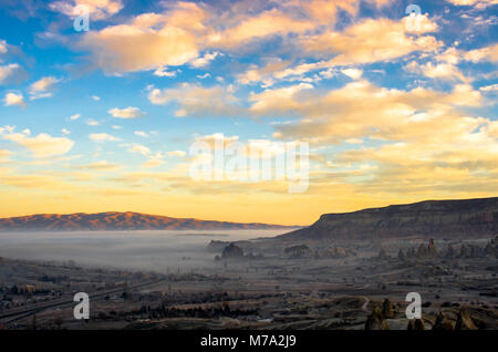 Orange Himmel über dem misty Roten Tal von Kappadokien, Türkei Stockfoto