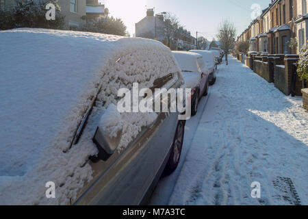 Autos im Schnee auf einer Londoner Straße nach einer kürzlichen Untergang Stockfoto