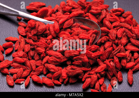 Ein Haufen von Goji Beeren sonst wie wolfberries ursprünglich aus China und ein Löffel bekannt.. Stockfoto