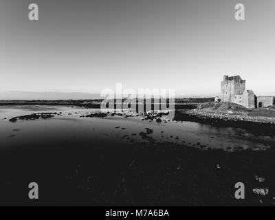 Schwarze und weiße Dunguaire Castle Schloss Sonnenuntergang am Abend, in der Nähe von Kinvarra in der Grafschaft Galway, Irland - wilden Atlantischen Strecke. Berühmte öffentliche touristische Anziehung, die ich Stockfoto