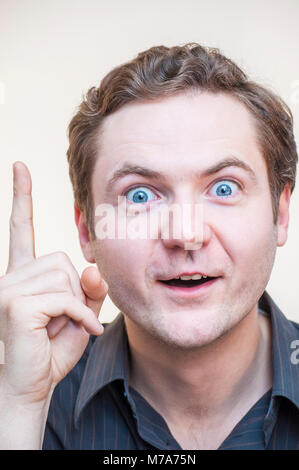 Porträt der jungen überrascht emotionale große Augen Mann mit offenen Mund bekam tolle Idee und zeigen mit dem Finger auf weißem Hintergrund. Stockfoto