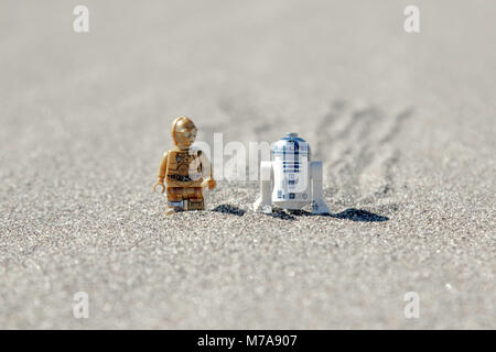 Lego C3p 0 und Lego R2D2 zu Fuß durch eine Sanddüne zusammen. Stockfoto