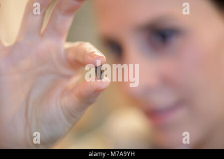 Frau hält in einem palm Korn von Kaffee Stockfoto