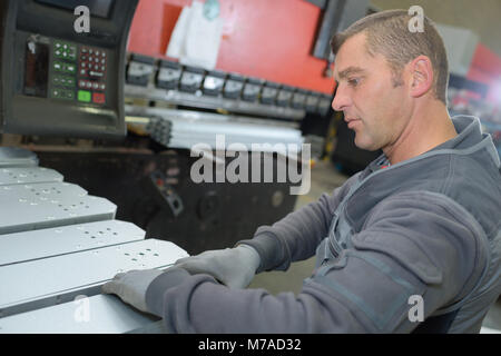 Mitarbeiter stehen vor riesigen industriellen Maschinen Stockfoto