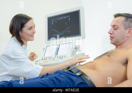 Ärzte hält eine Sonde während der Abdominal- Ultraschall Prüfung Stockfoto