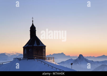 Kirche Heilig Kreuz auf dem Wallberg mit Blick auf die Tegernseer Berge im Mangfallgebirge und die bemerkenswerte Buchstein am Abend, Rottach-Egern, Oberbayern, Bayern, Süddeutschland, Deutschland, Stockfoto