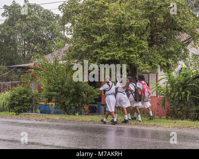 Ambon, Indonesien - 12. Februar 2018: Kinder in der weißen Uniformen zurück aus der Schule in der Regen Stockfoto