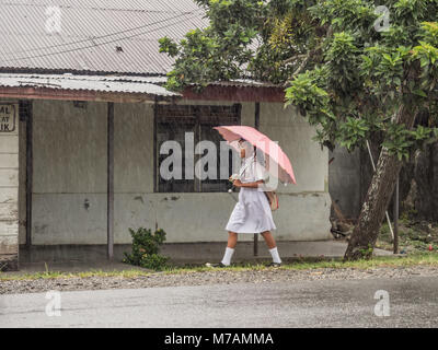 Ambon, Indonesien - 12. Februar 2018: Kinder in der weißen Uniformen zurück aus der Schule in der Regen Stockfoto