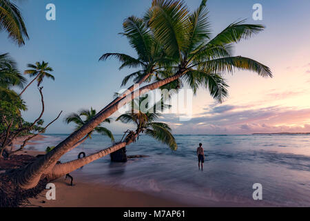 Mann auf einer verlassenen wilden Strand bei Sonnenaufgang auf der karibischen Insel Puerto Rico Stockfoto