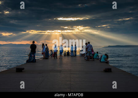 Touristen beobachten die Sonne bricht durch die Wolken über den Amur in Wladiwostok, Russland Stockfoto