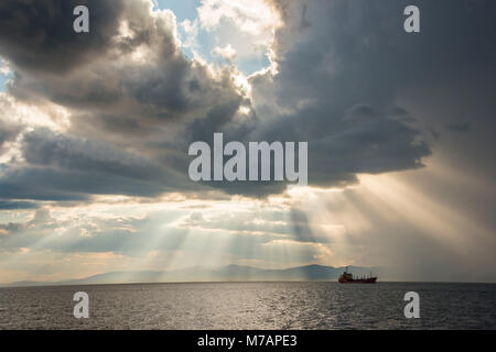 Schiff, bevor die Sonne durch die Wolken über den Amur in Wladiwostok, Russland brechen Stockfoto