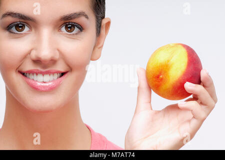 Porträt einer Frau mit einem Pfirsich Stockfoto