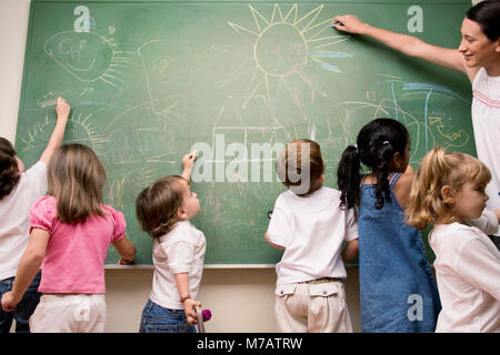 Weibliche Lehrer unterrichten ihre Schüler in einem Klassenzimmer Stockfoto