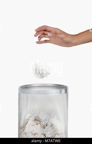 Nahaufnahme der Hand einer Frau werfen zerknittertes Papier in einem Papierkorb Stockfoto