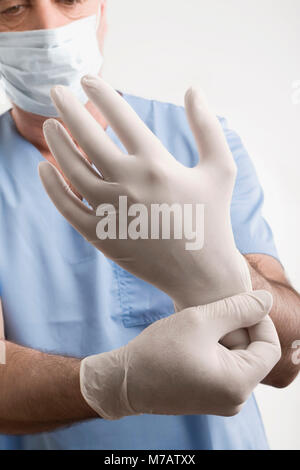 Männliche Chirurgen setzen auf OP-Handschuhe Stockfoto