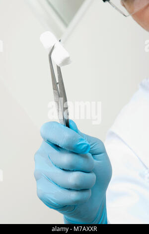 Nahaufnahme einer Zahnarzt holding Baumwolle in Pinzetten Stockfoto