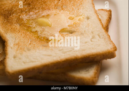 Zwei Scheiben Toast mit Butter auf einem Teller Stockfoto