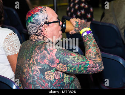 Ein Mann entspannt sich mit einem Kaffee an der australischen Tattoo Expo, International Convention Centre, Darling Harbour, Sydney. Diese Veranstaltung stellt die Kultur des Körpers Tinte und fördert auch die Fähigkeiten der weltbekannte Künstler in Australien und auf der ganzen Welt. Credit: Paul Lovelace/Alamy leben Nachrichten Stockfoto