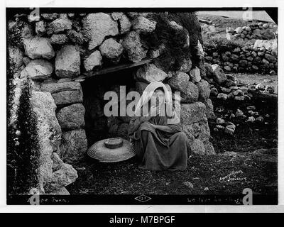 Das Bild zeigt verschiedene Kostüme, Charaktere und Zeremonien neben einem Dorfofen. Diese Szene zeigt traditionelle Kostüme, die während kultureller oder zeremonieller Veranstaltungen getragen werden. Stockfoto