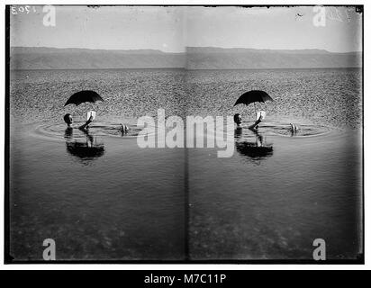 Um das Tote Meer. Mann floating mit Buch und Regenschirm in Händen LOC 01738 matpc. Stockfoto