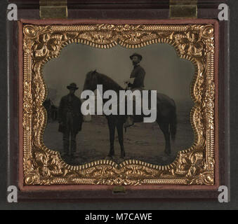 Ein Foto, das zwei unidentifizierte Unions-Soldaten aus dem Amerikanischen Bürgerkrieg zeigt, einen Afroamerikaner und den anderen auf einem Pferd sitzend, beide in typischen Uniformen der Union. Stockfoto