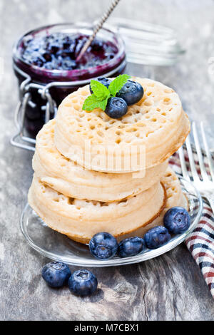 Hot geröstetes Fladenbrot auf dem Holztisch mit Blaubeeren und Marmelade Stockfoto