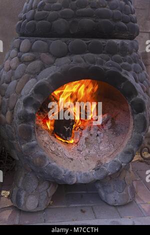 Vertikales Porträt Ausschneiden des Feuers in altem Steinkamin mit Holzkohle Stockfoto