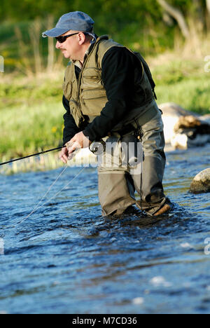 Reifer Mann angeln im Fluss Stockfoto