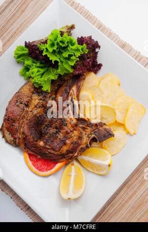 Erhöhte Ansicht der Schweinekoteletts mit Bratkartoffeln serviert Stockfoto
