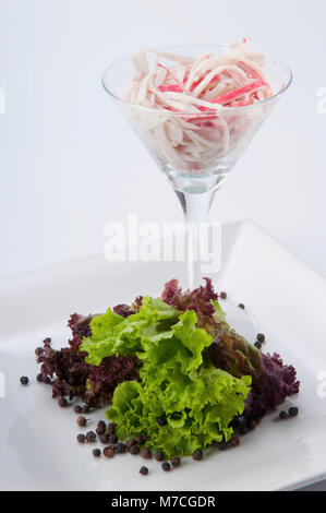 Nahaufnahme eines Tintenfischs cocktail mit Salat und schwarzem Pfeffer Stockfoto