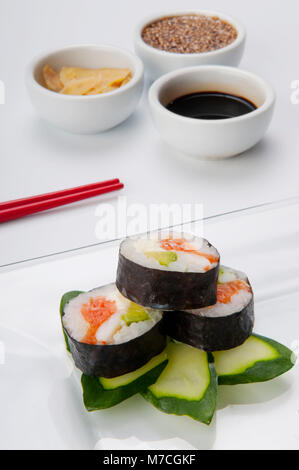 Nahaufnahme von Sushi Rollen auf Zucchini mit Gewürzen Stockfoto