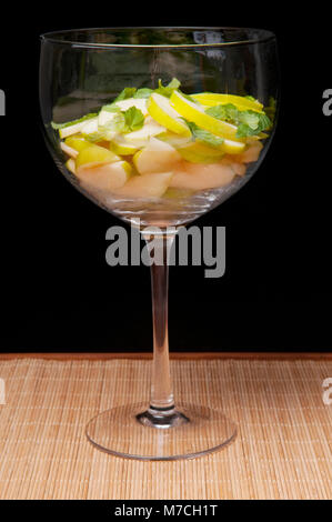 Nahaufnahme von Knoblauch mit Zitrone und Minze in ein Glas Wein Stockfoto