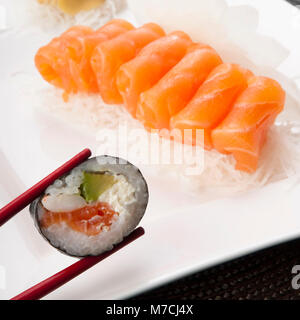 Nahaufnahme von Sushi mit Stäbchen statt Stockfoto