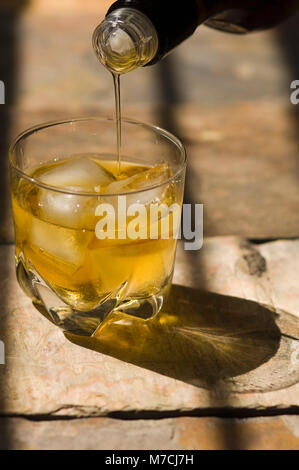 Nahaufnahme von Whisky in ein Glas gegossen wird Stockfoto