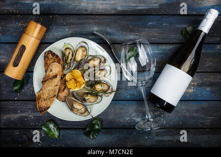 Muscheln und Brot Toast auf einem weißen Teller. Ansicht von oben Stockfoto