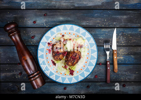 Türkei Schnitzel mit frischen Beeren und saucea Eisberg Salat mit Besteck und Pepper Grinder serviert. Stockfoto