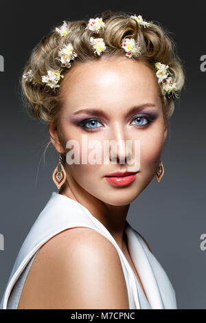 Schöne blonde junge Frau in Weiß top mit blühenden Kastanien Blumen im Haar. studio Beauty Shot. kopieren. Stockfoto