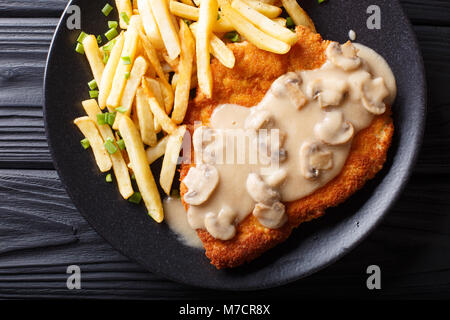 Knusprig gebratene Schweinekoteletts (Jaeger Schnitzel) mit Sauce und Pommes frites Close-up auf einem Teller. horizontal oben Ansicht von oben Stockfoto