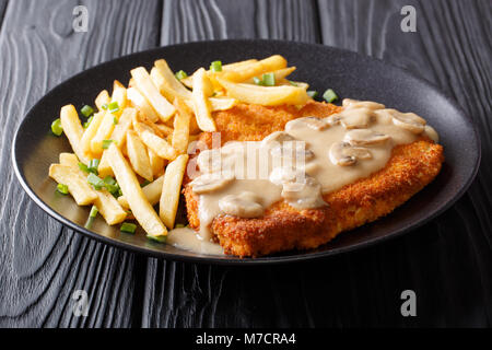 Knusprig gebratene Schweinekoteletts (Jaeger Schnitzel) mit Sauce und Pommes frites Close-up auf einem Teller. Horizontale Stockfoto